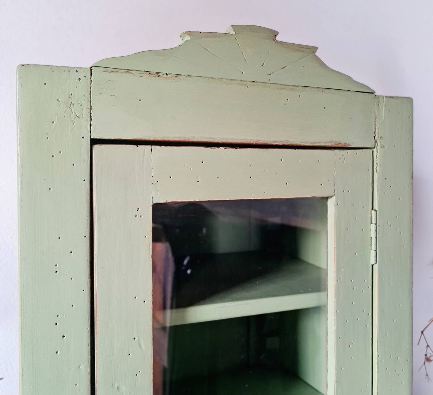 Small glass cabinet in green colour.