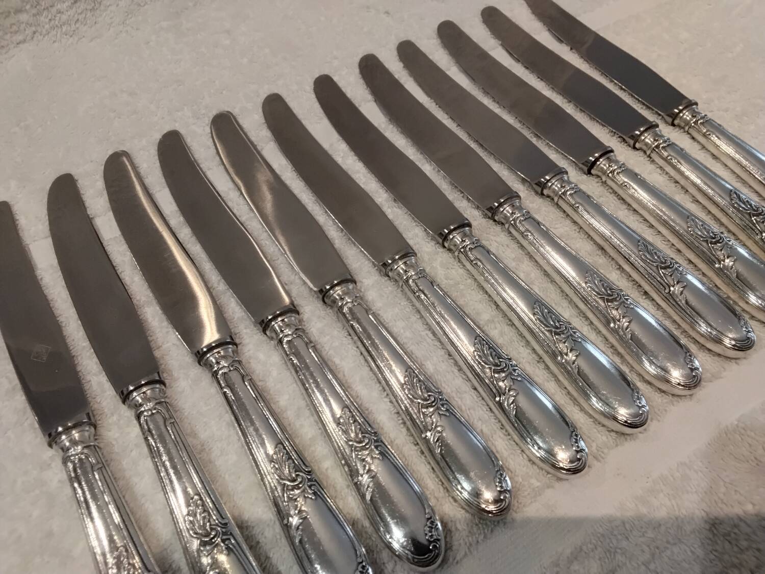 12 silver-plated metal table knives with rocaille ribbon decoration, 25.1 cm
