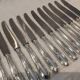 12 silver-plated metal table knives with rocaille ribbon decoration, 25.1 cm