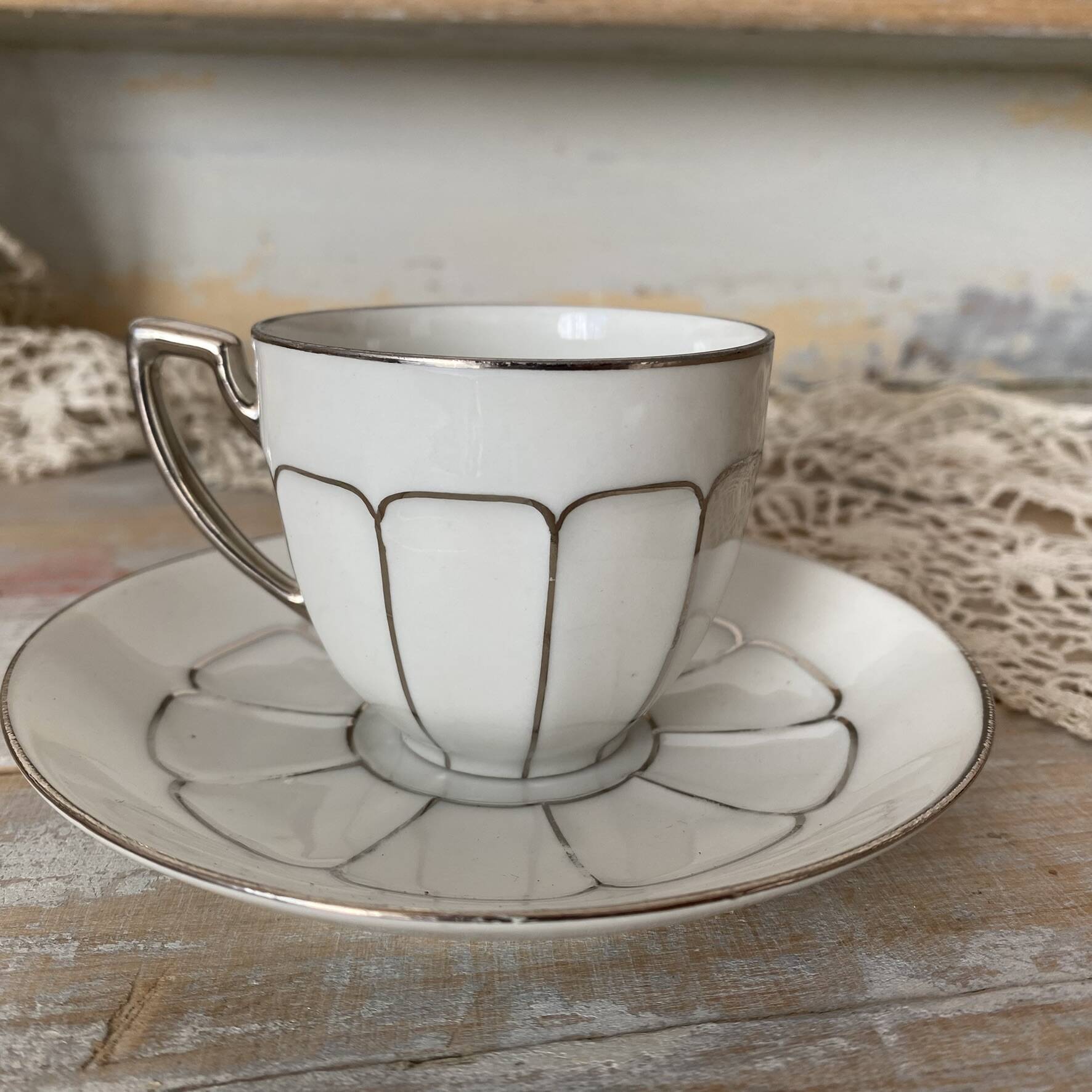 White and silver Limoges porcelain coffee cups and saucers.