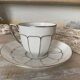 White and silver Limoges porcelain coffee cups and saucers.
