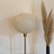 Table lamp with a white striped glass globe lampshade and a gold base