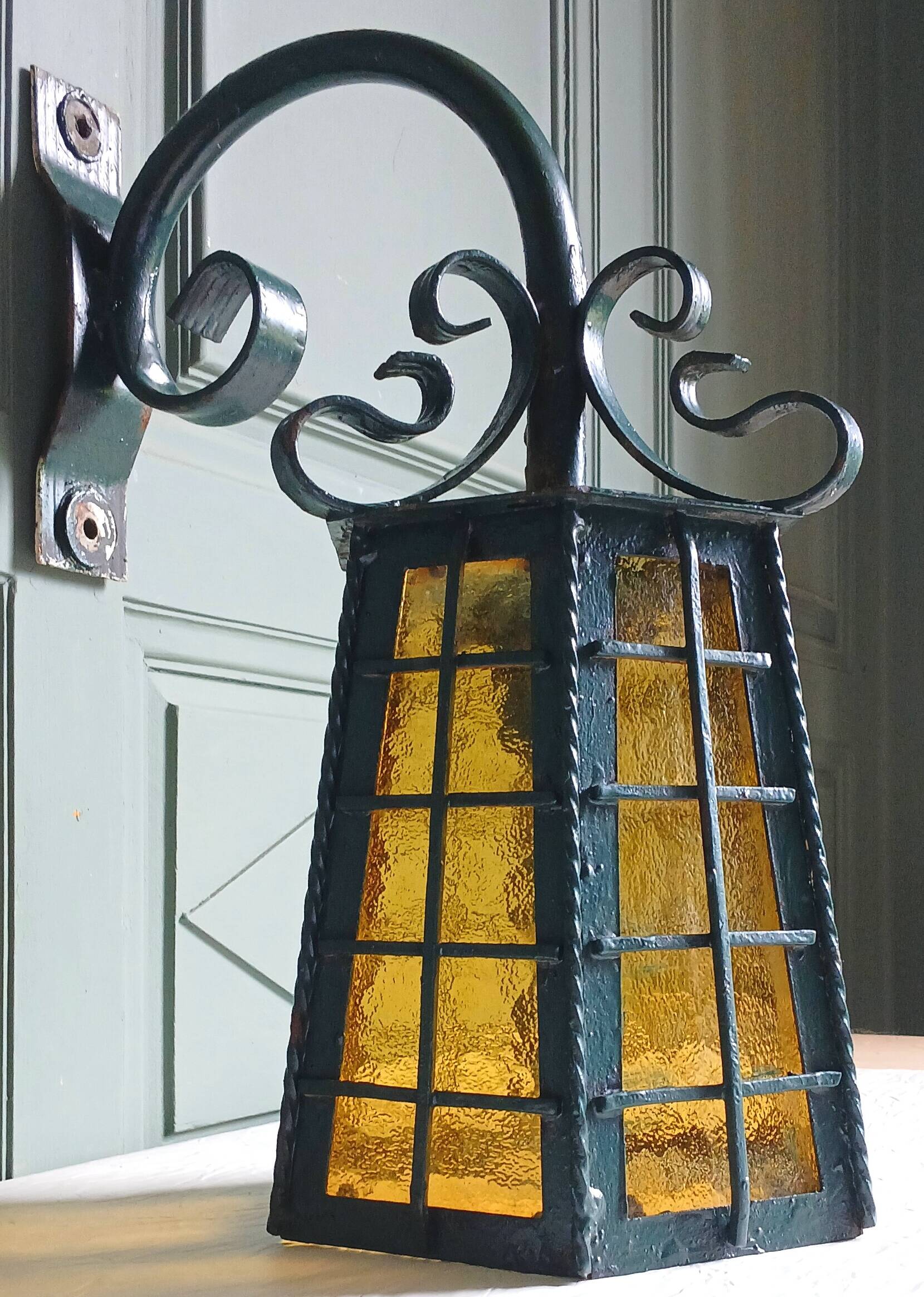 Wrought iron wall lantern & amber cathedral glass