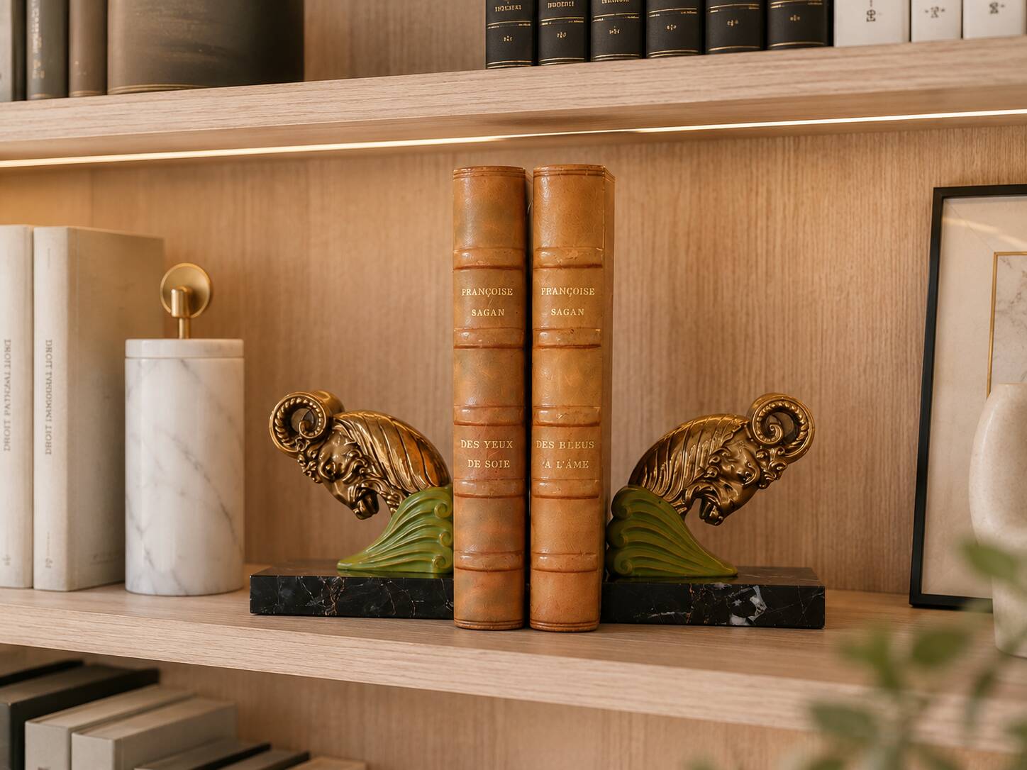 Art Deco pair of bookends with ram's heads, patinated metal and black marble.