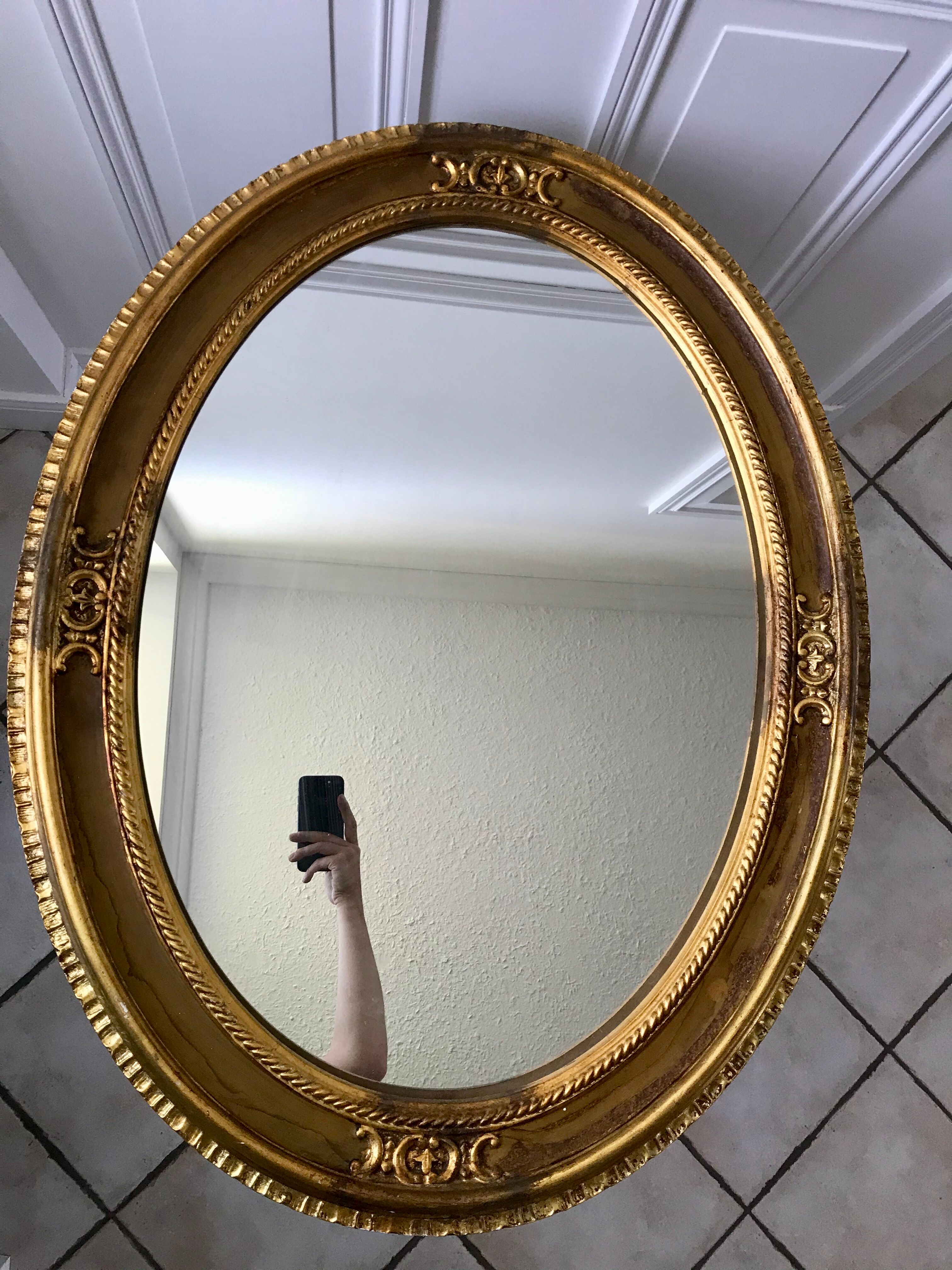 Grand miroir oval en stuc doré vintage