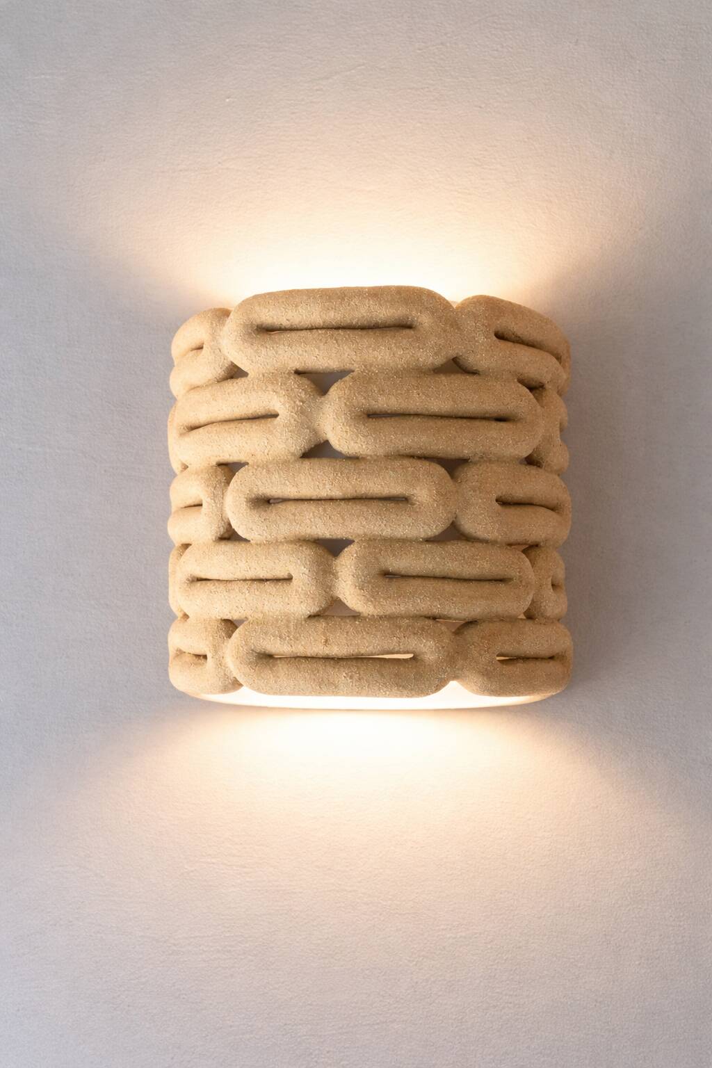 Handcrafted ceramic wall light in raw stoneware inspired by Mid Century design.