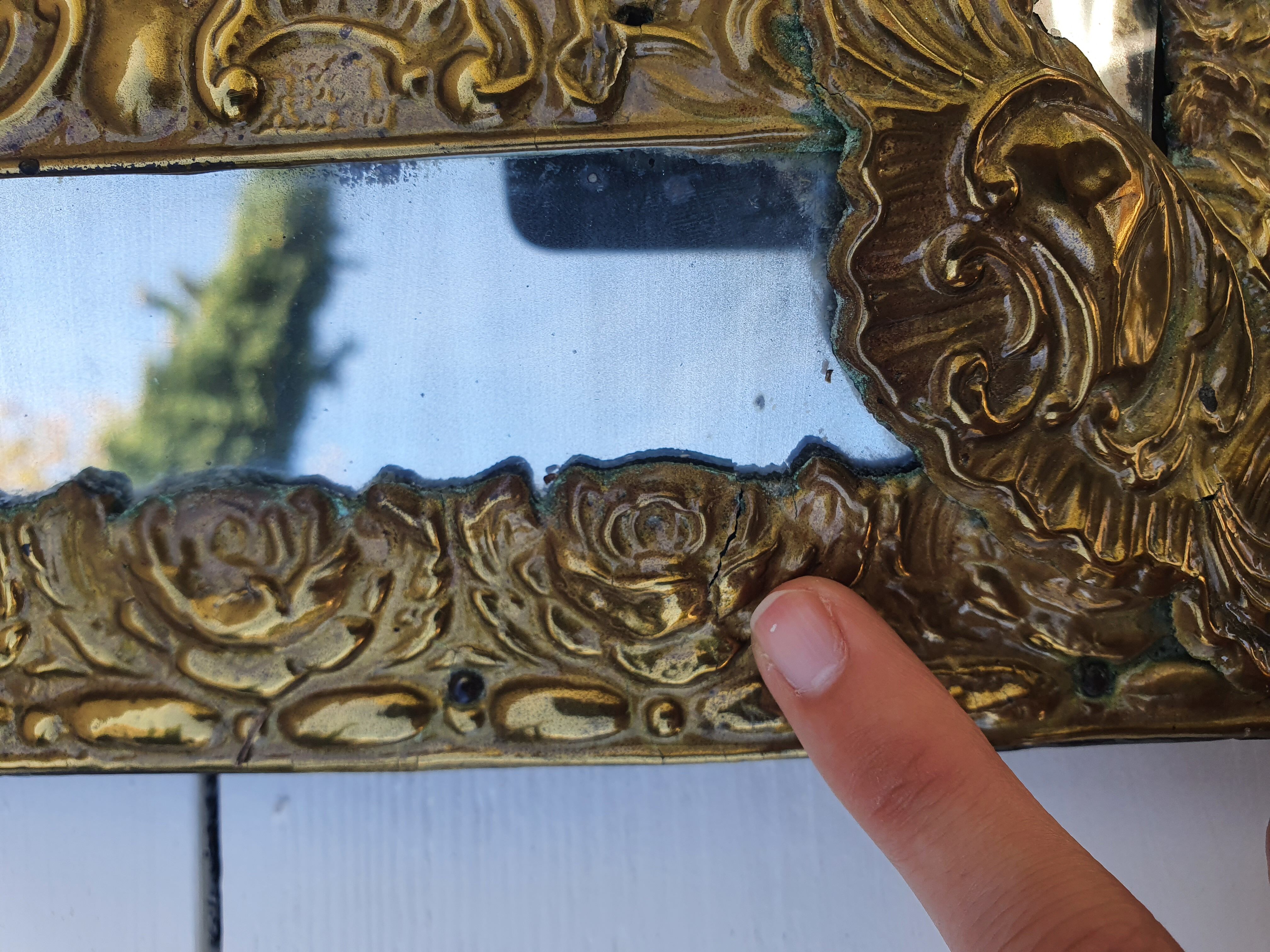 Miroir à parecloses en bois doré et métal repoussé