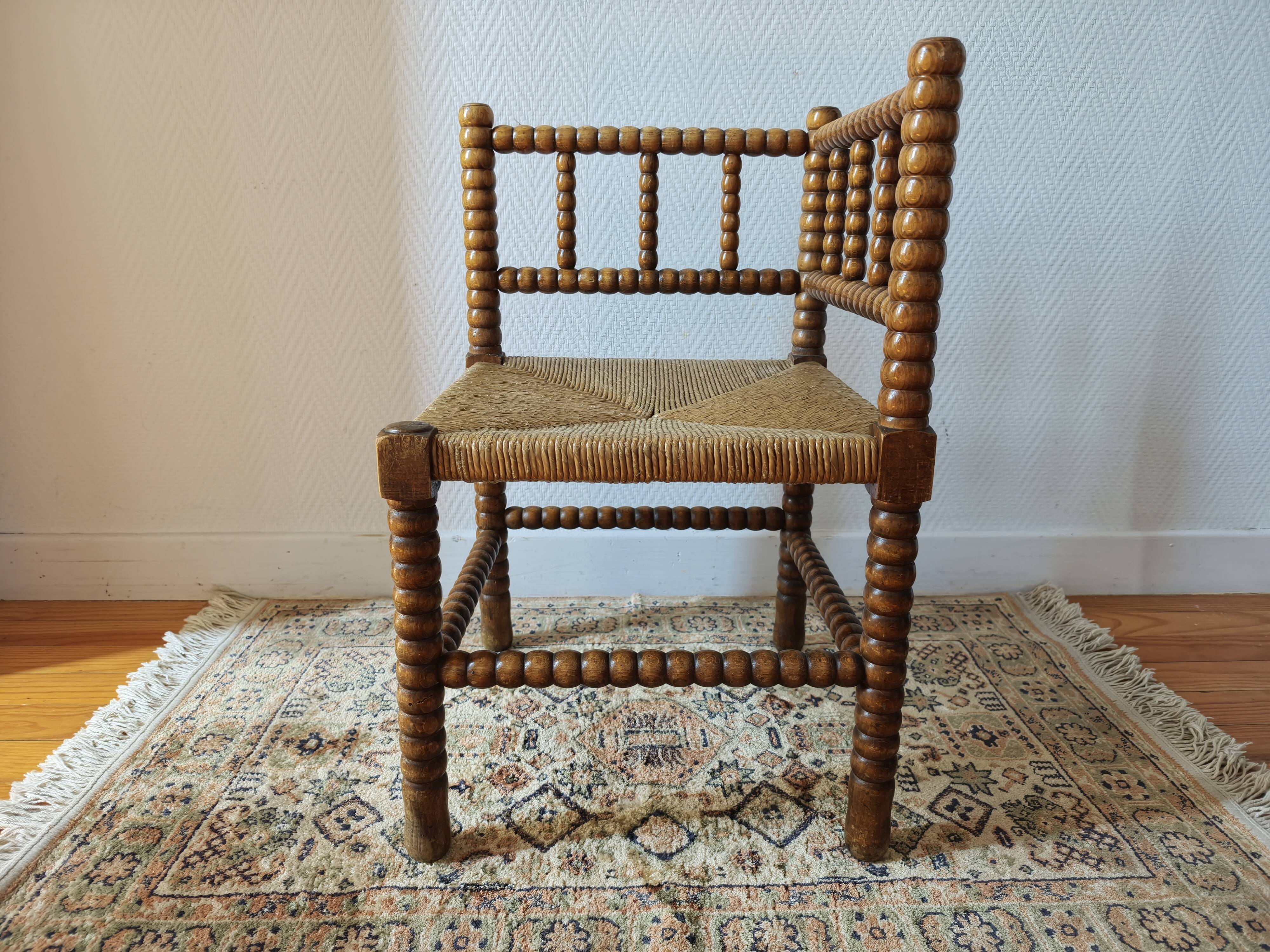 Antique corner chair by the fire with turned wood and straw seat.