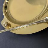 Round brass pocket tray with club and golf ball decoration.
