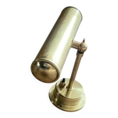 Antique brass wall sconce for illuminating a painting.