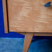 Rockabilly design bedside table with tapered legs.
