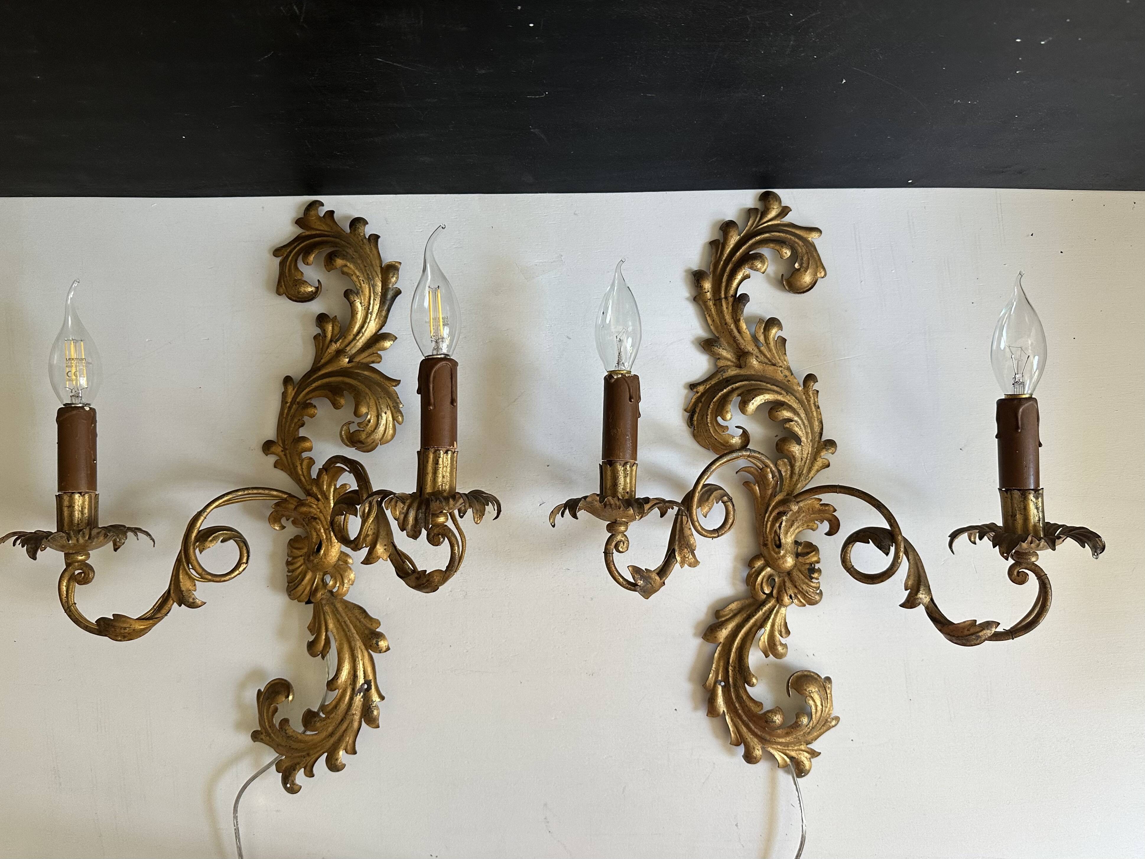 Pair of Italian Hollywood Regency wall lights in iron and gilded sheet metal.