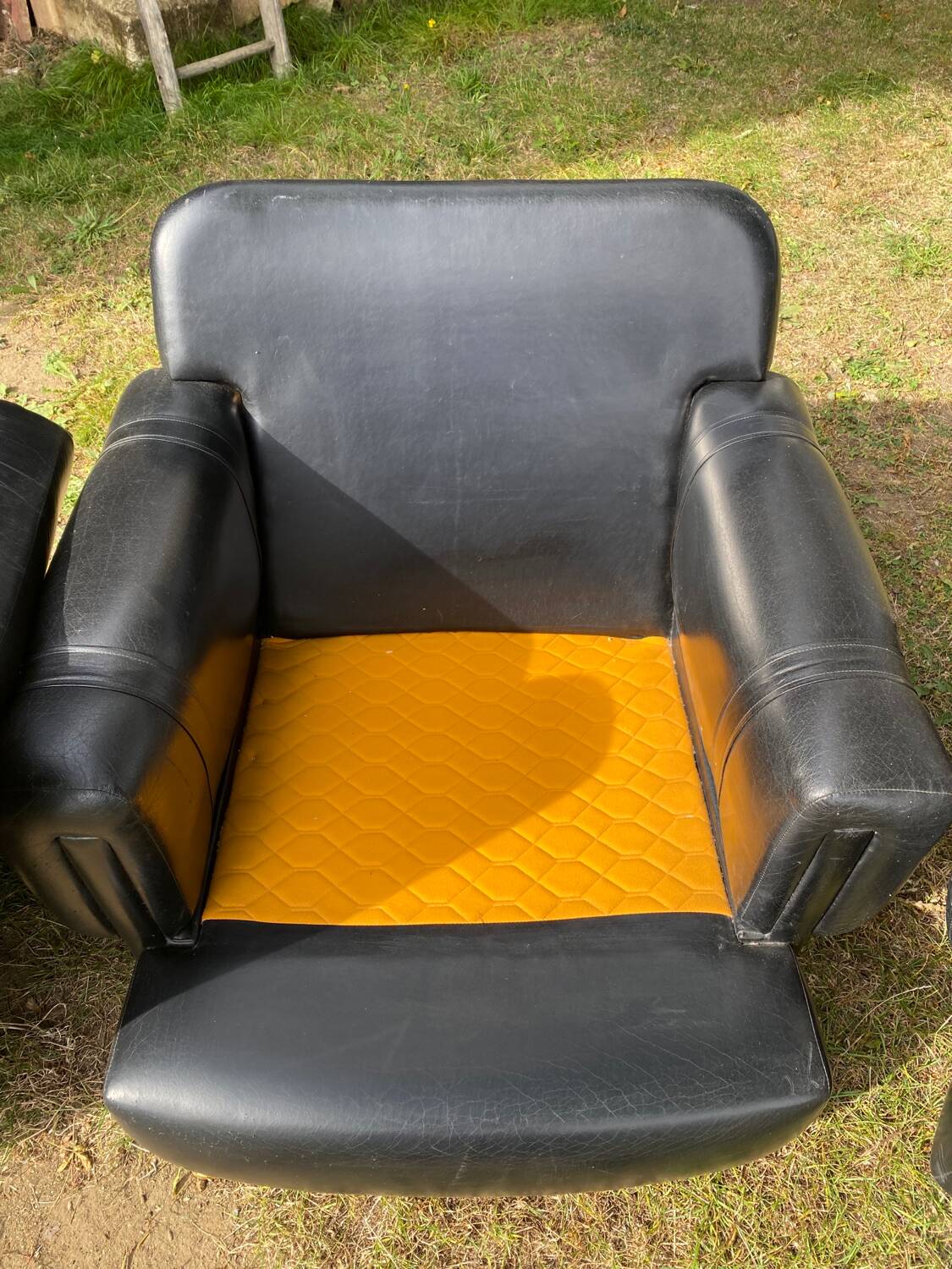 Pair of black imitation leather armchairs