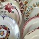 Set of 8 ironstone plates with coordinated designs.