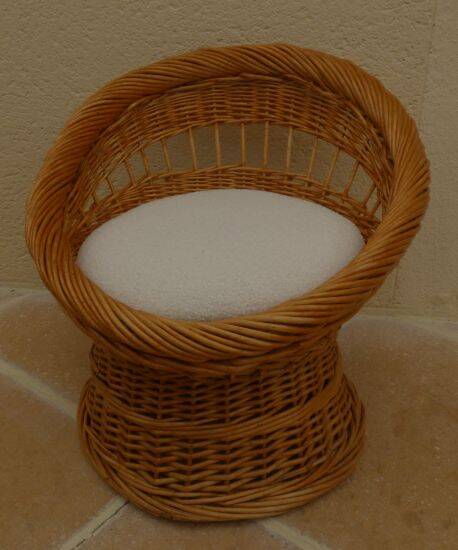 Wicker armchair with a high back and its boucle fabric cushion.