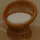 Wicker armchair with a high back and its boucle fabric cushion.