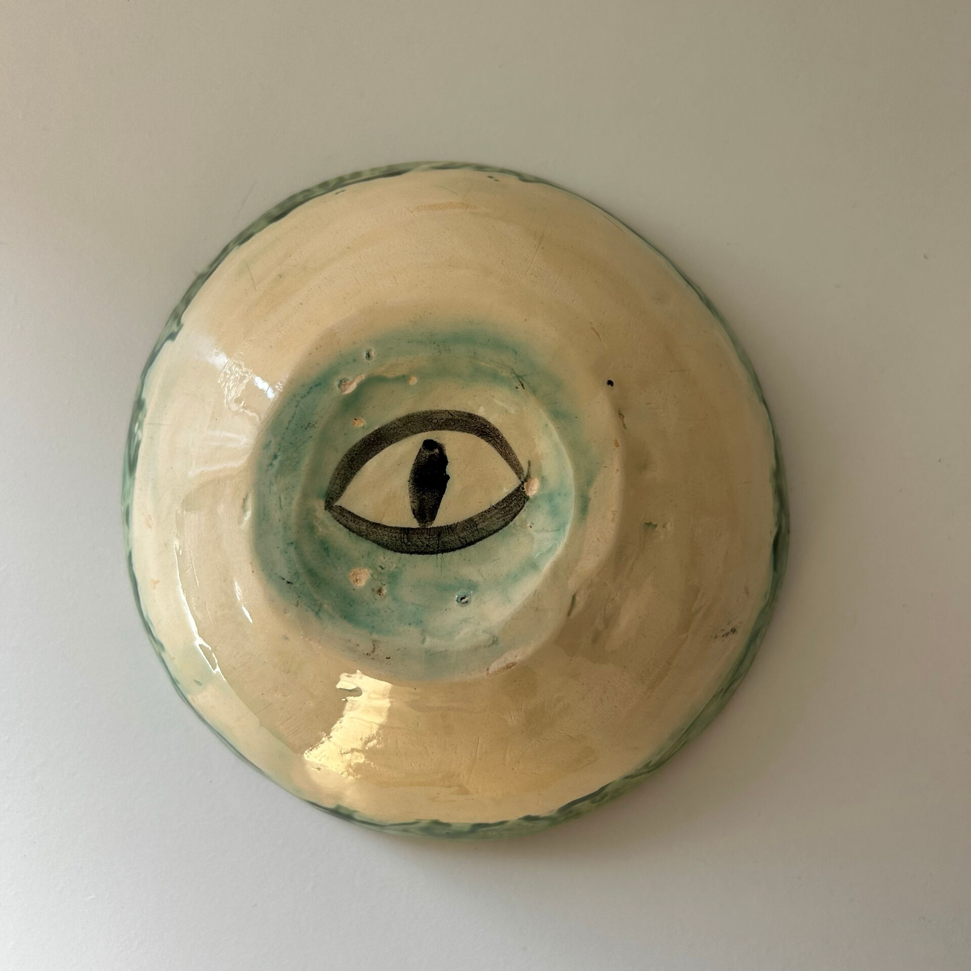 Green bowl signed with an eye