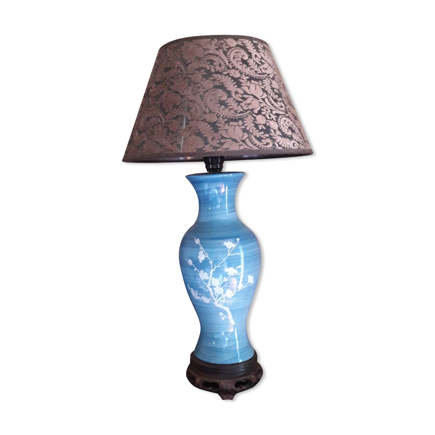 Large blue porcelain lamp with white flowers (cherry blossoms) on wooden stand.