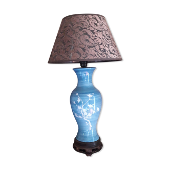 Large blue porcelain lamp with white flowers (cherry blossoms) on wooden stand.
