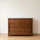 Antique wooden chest of drawers with a marble top.