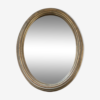 Miroir ovale classique en bois doré.