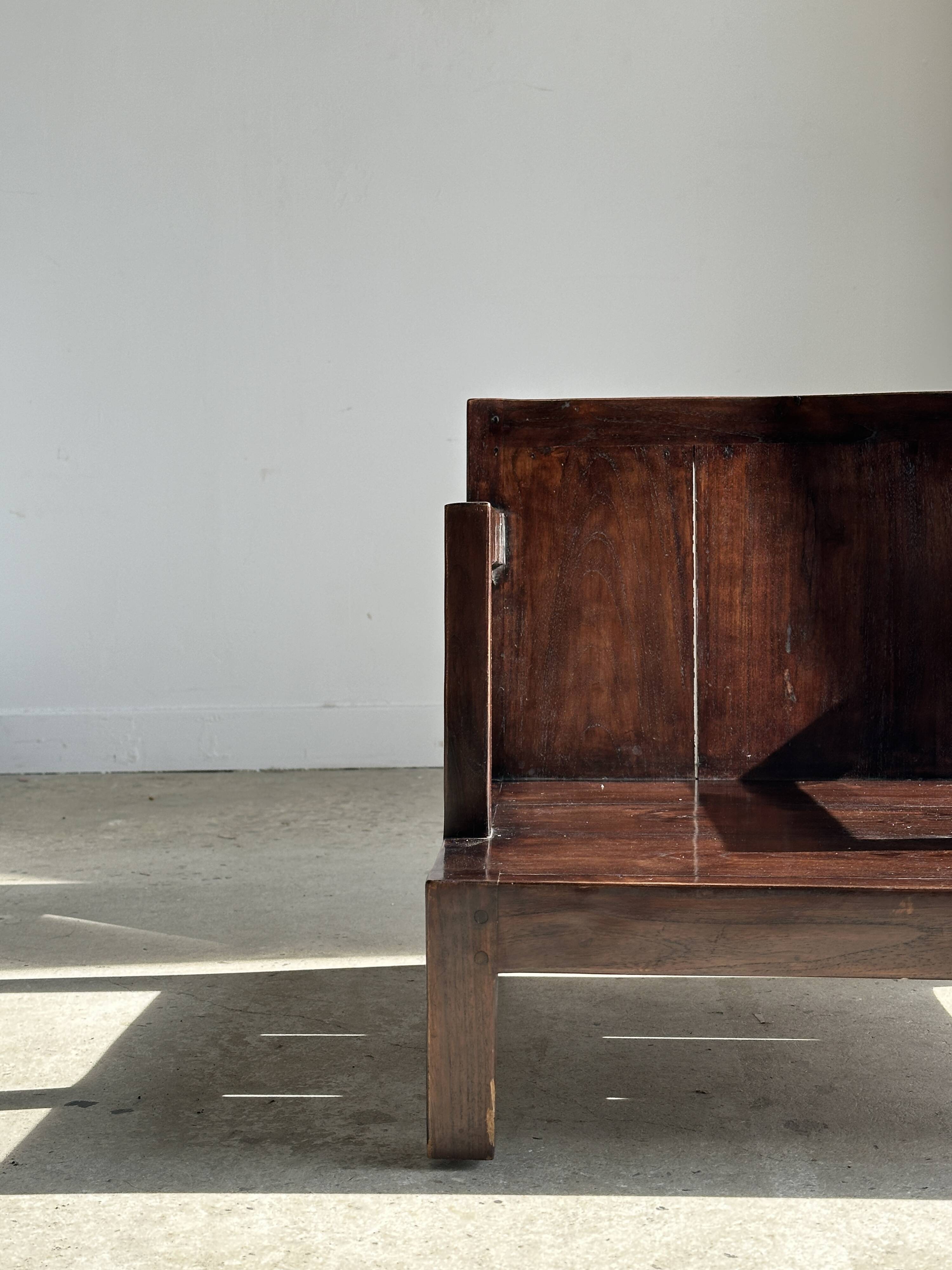 Small low armchair in varnished brown wood