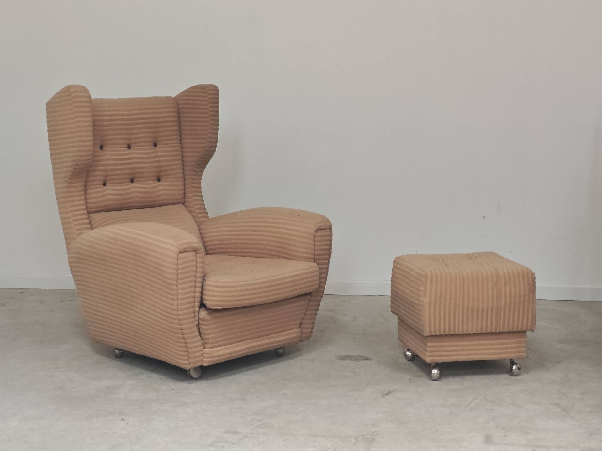 Beige wingback armchair and TVAR footrest, former Czechoslovakia.
