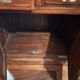 Antique solid wood secretary with a drop-down cylinder compartment.