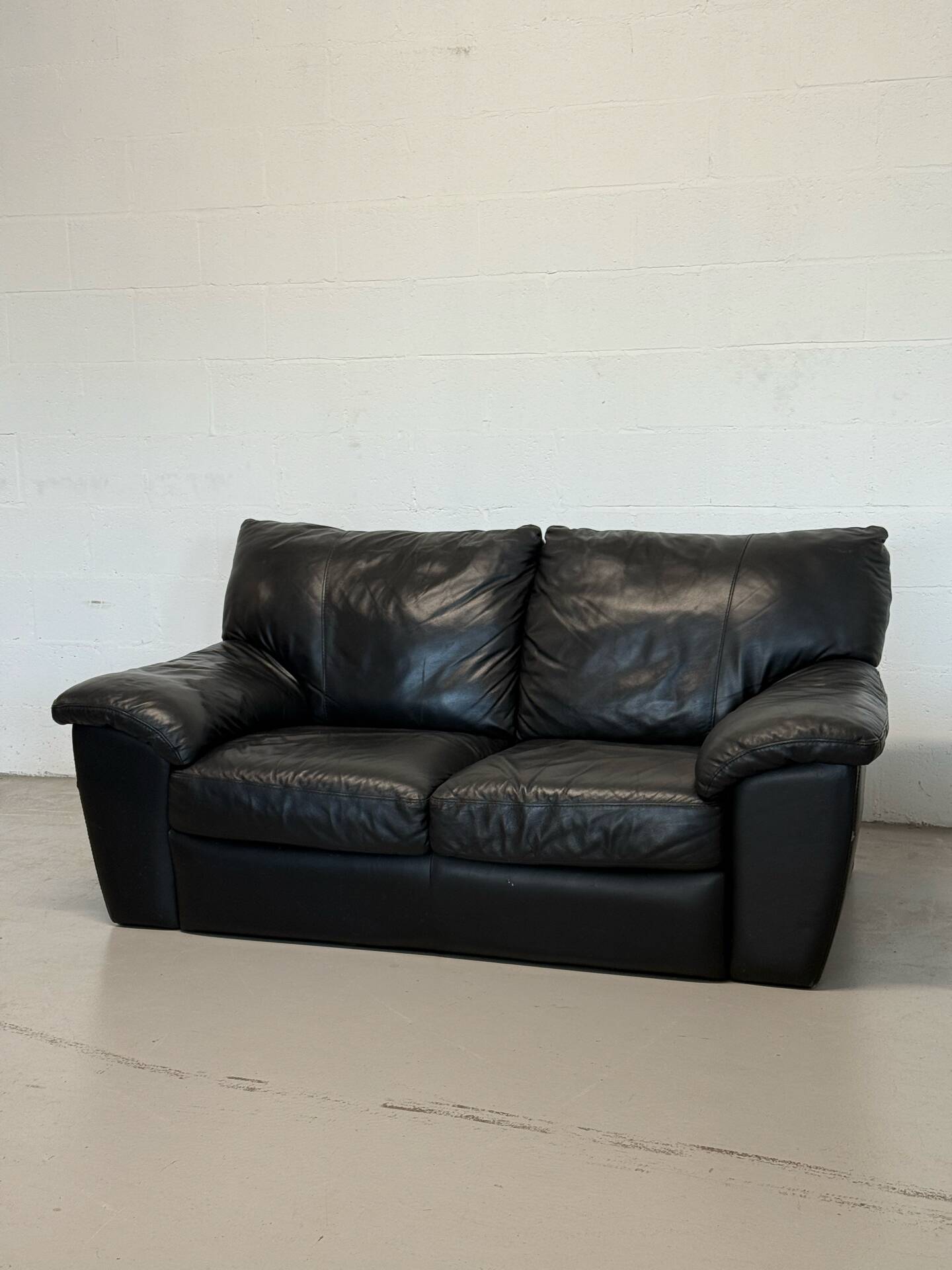 Two-seater black leather sofa — postmodern design