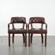 Set of two brown leather Chesterfield dining chairs in English style.