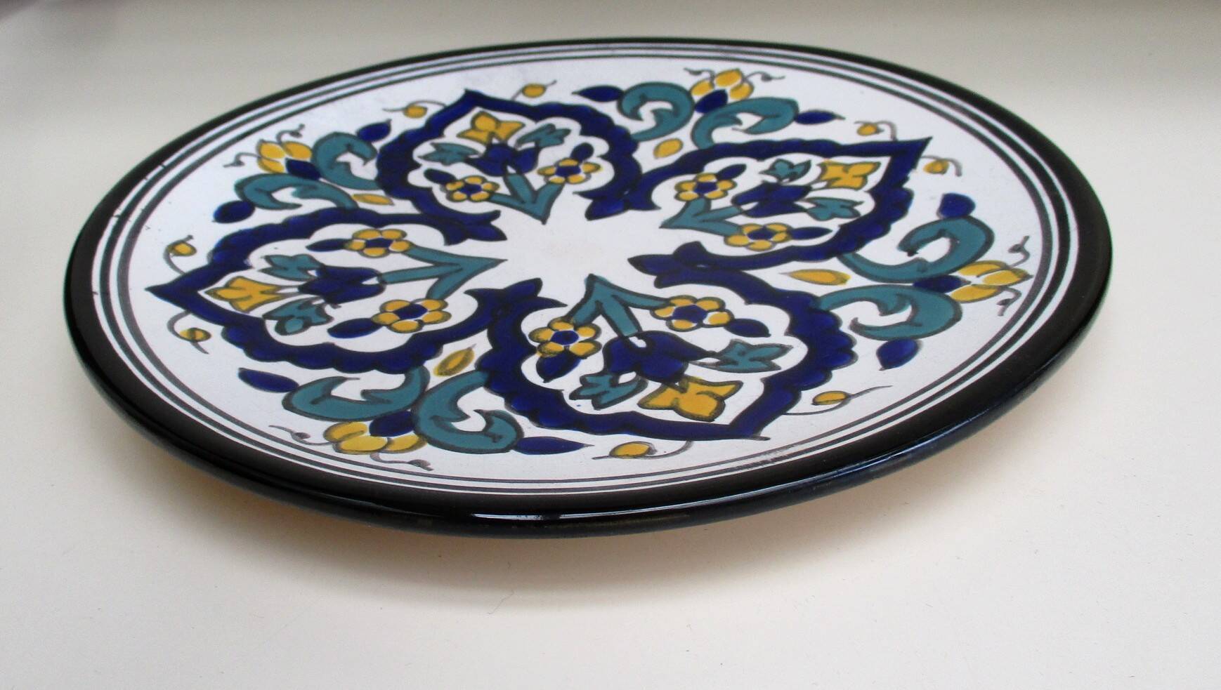 Round ceramic plate with hand-painted decoration