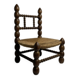 Brutalist wood turned bobbin low rush chair in the style of Charles Dudouyt