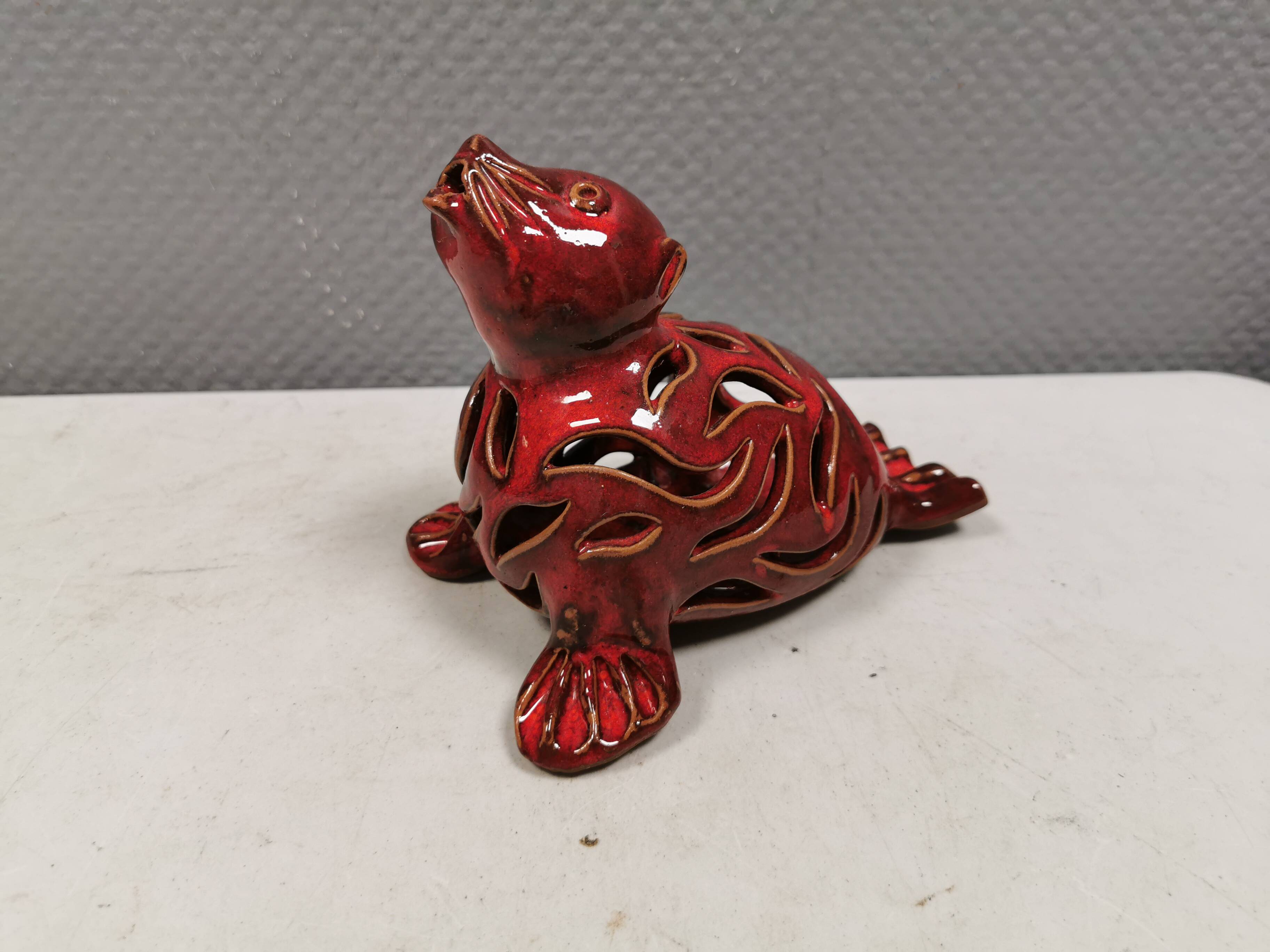 Beautiful seal in ceramic with metallic red glaze.