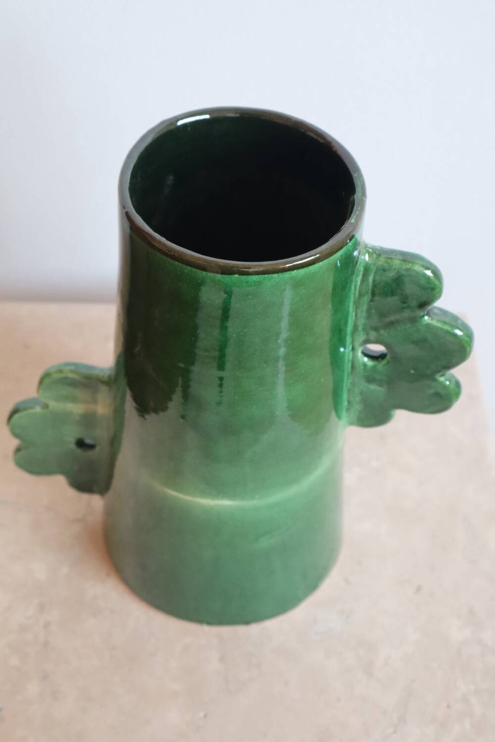 Handmade ceramic abstract vase with asymmetrical handles and fir green flowers