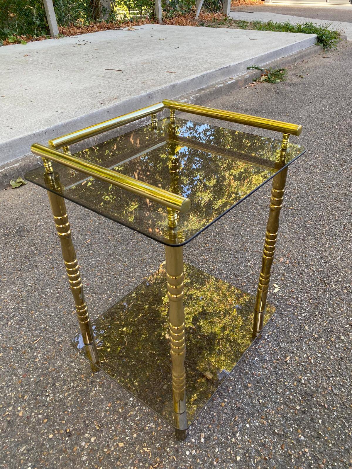 Vintage side table with smoked glass and sculpted golden brass, Hollywood Regency style.
