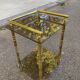 Vintage side table with smoked glass and sculpted golden brass, Hollywood Regency style.