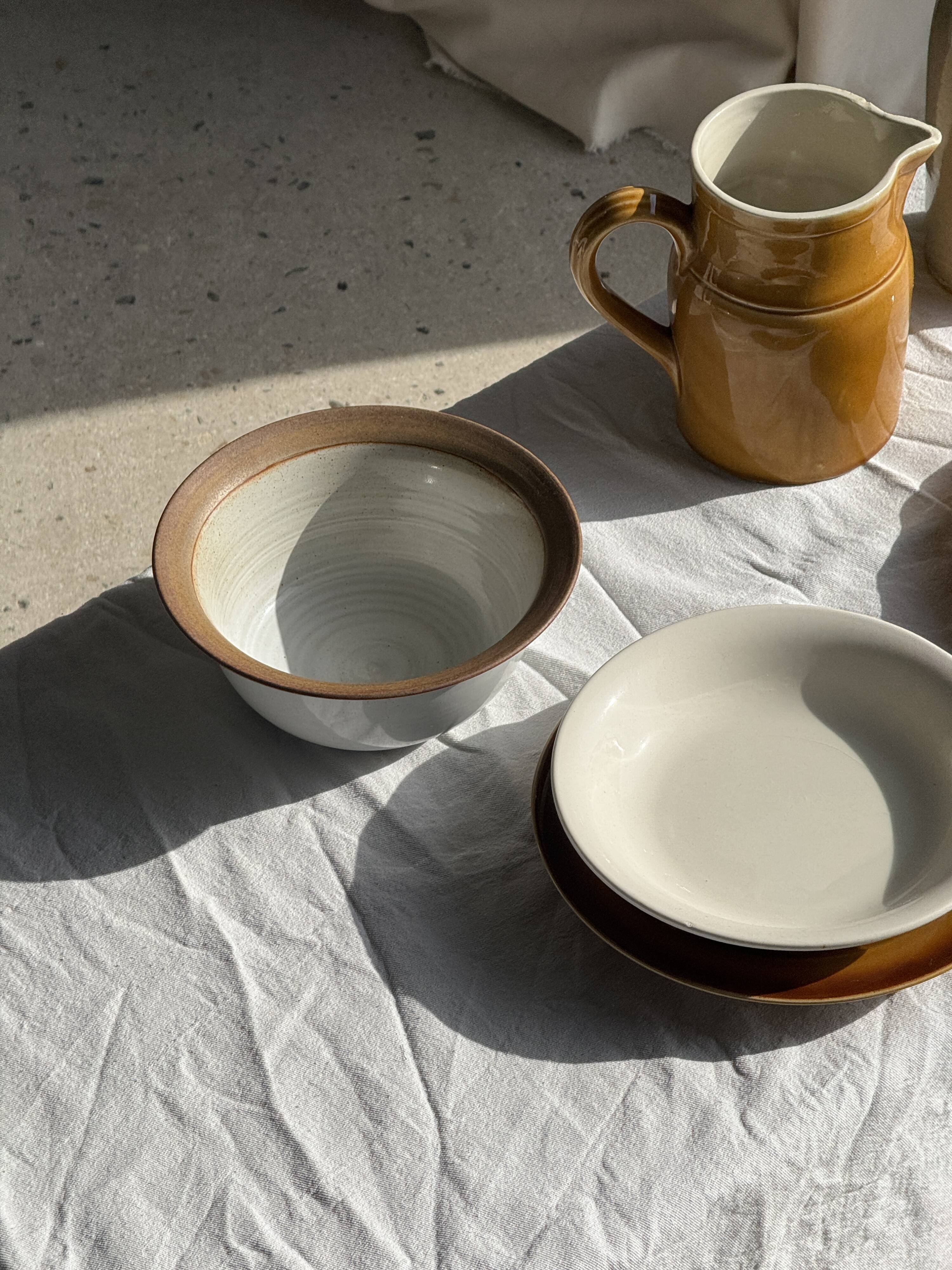 Small thick stoneware bowl with a stylised flower pattern in white on the outside, b