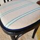 Curved black wooden bistro chair with striped seat