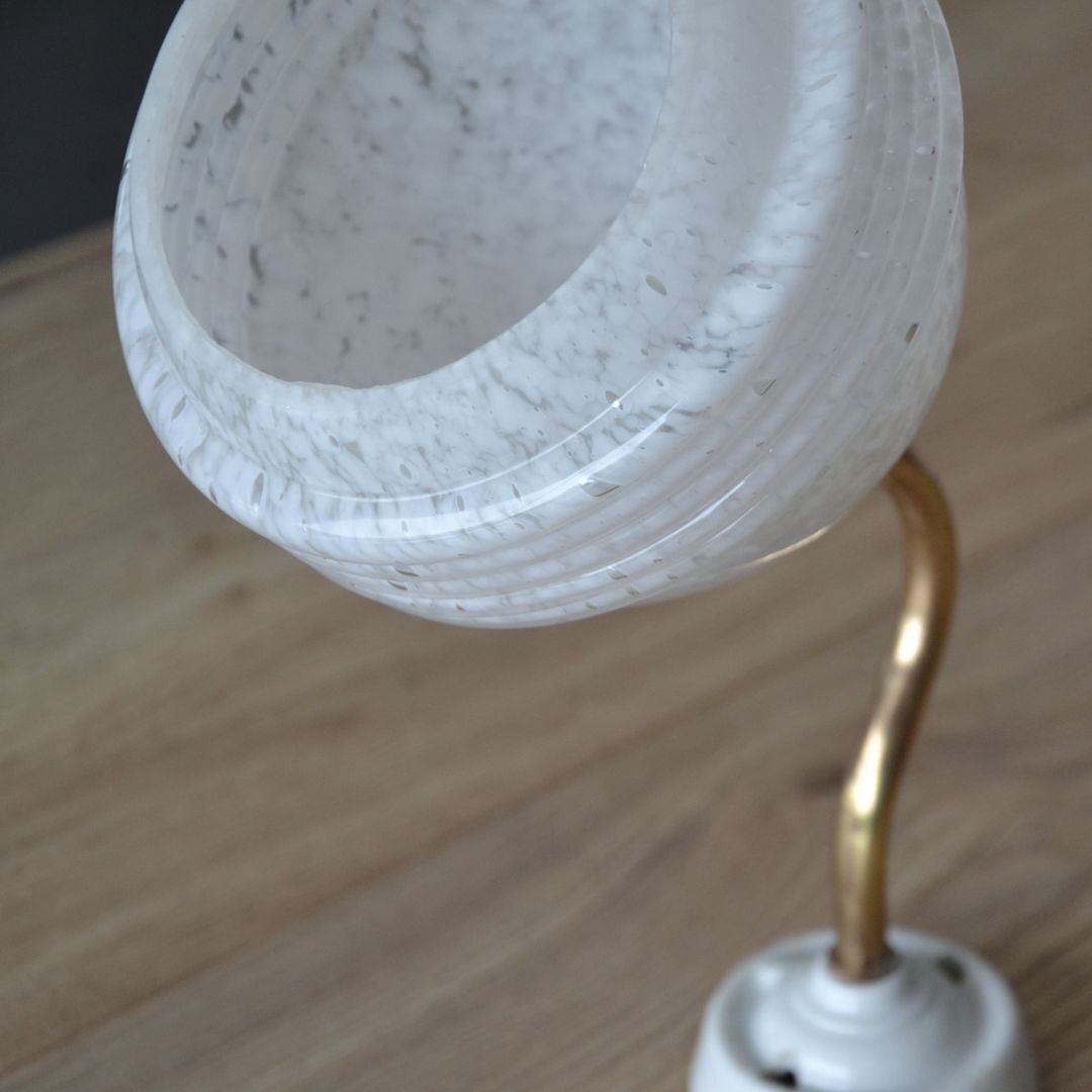 White Clichy glass globe wall light, porcelain support and gooseneck stem in brass