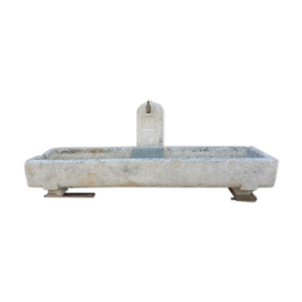 Natural stone garden fountain in the shape of a drinking trough