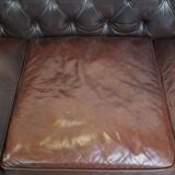 Old dark brown 3-seater cowhide chesterfield sofa with lots of character