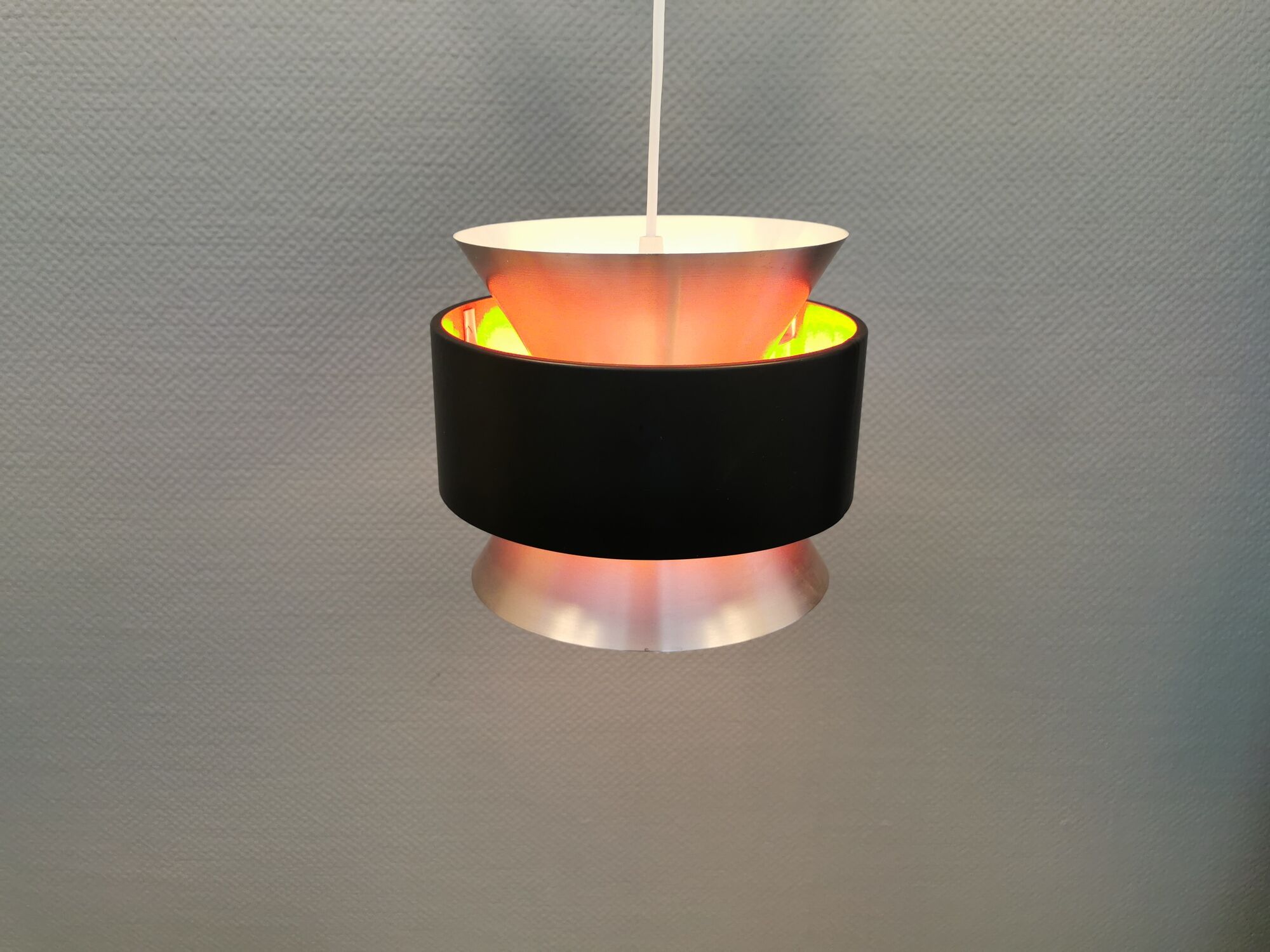 Hanging lamp,  of silver coloured aluminium with black "ring" and orange inner contrast lacquer.