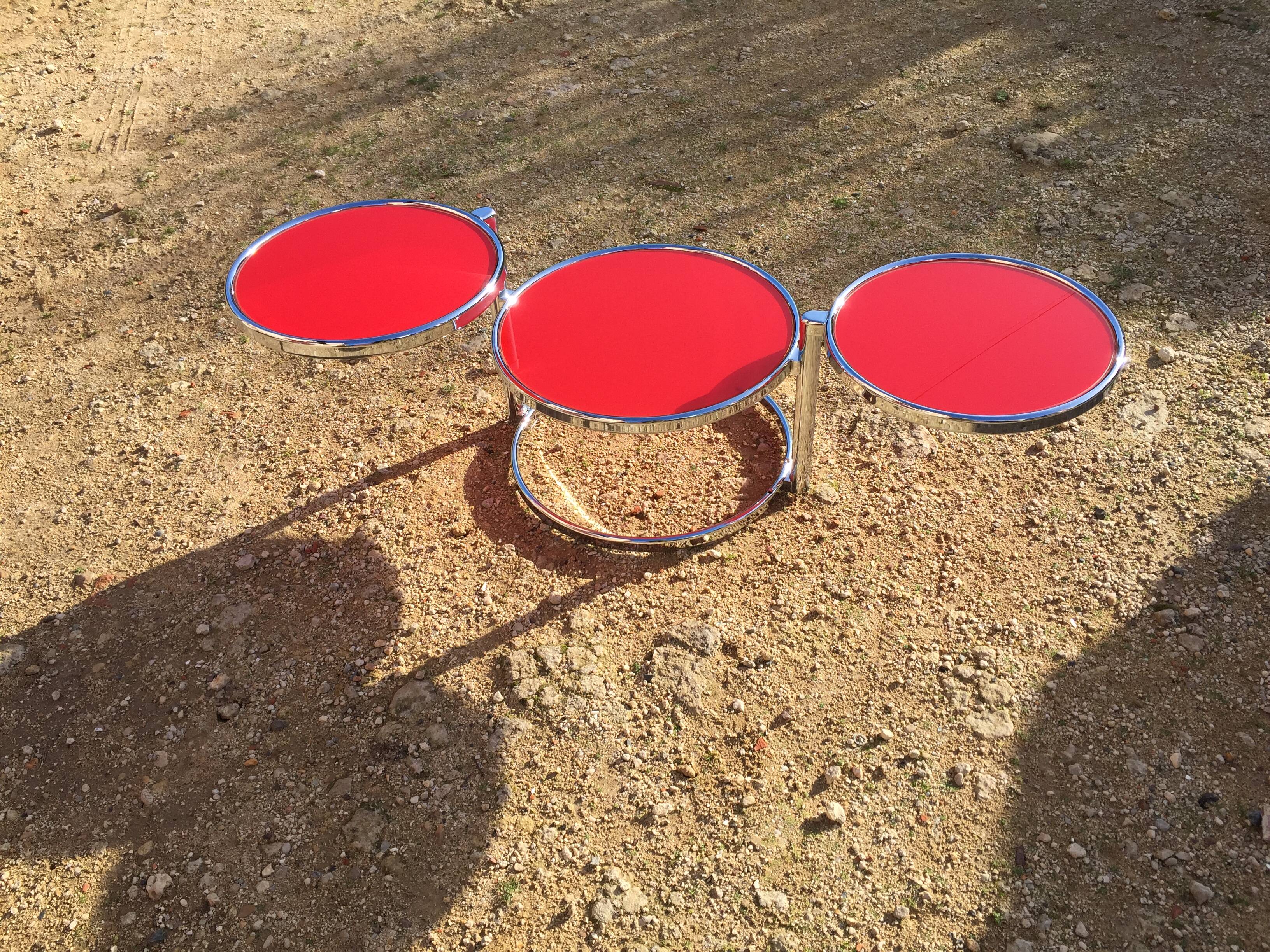 Table basse trois plateaux pivotants en verre rouge et métal chromé