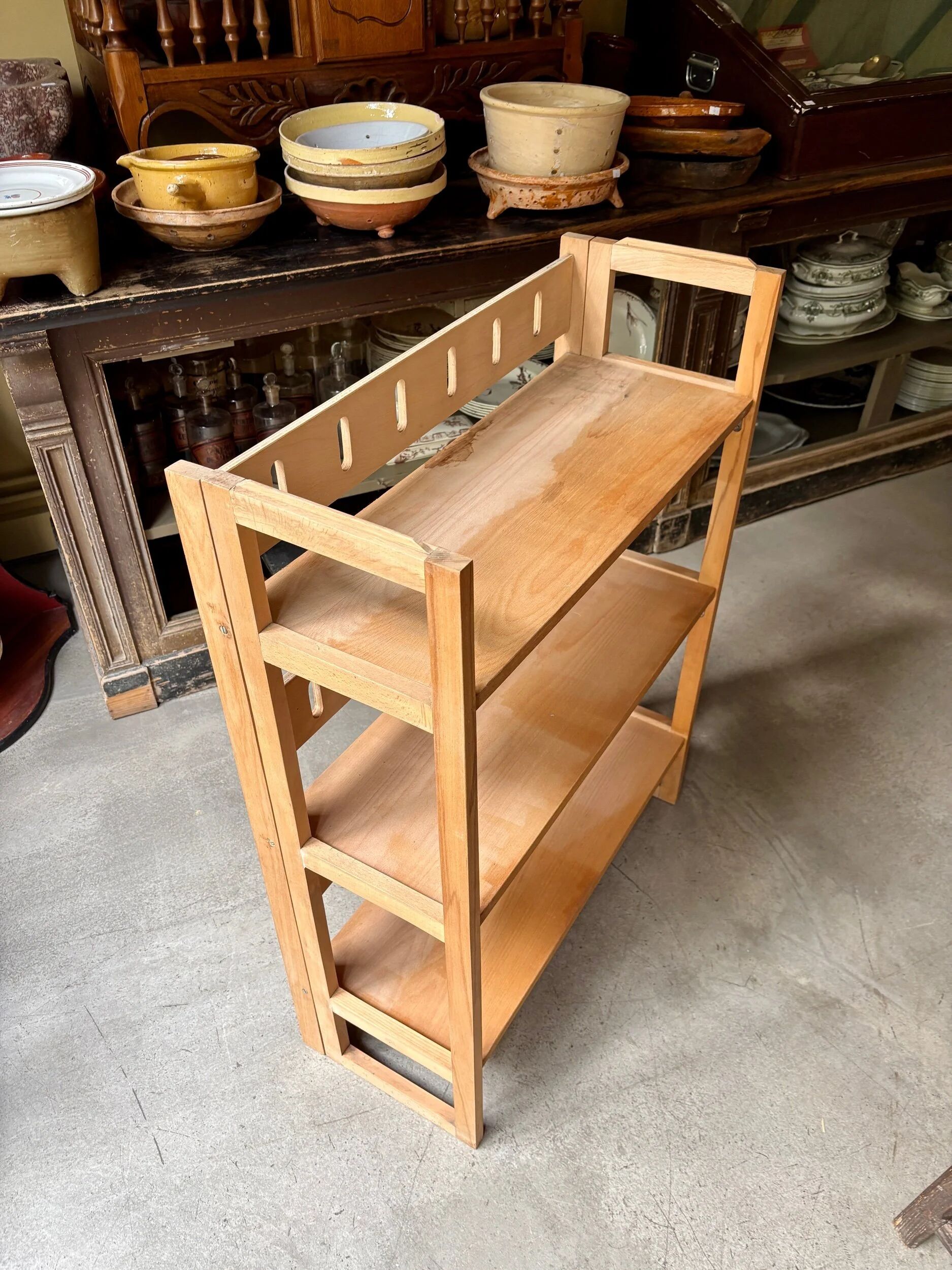 Folding bookshelf in light wood.