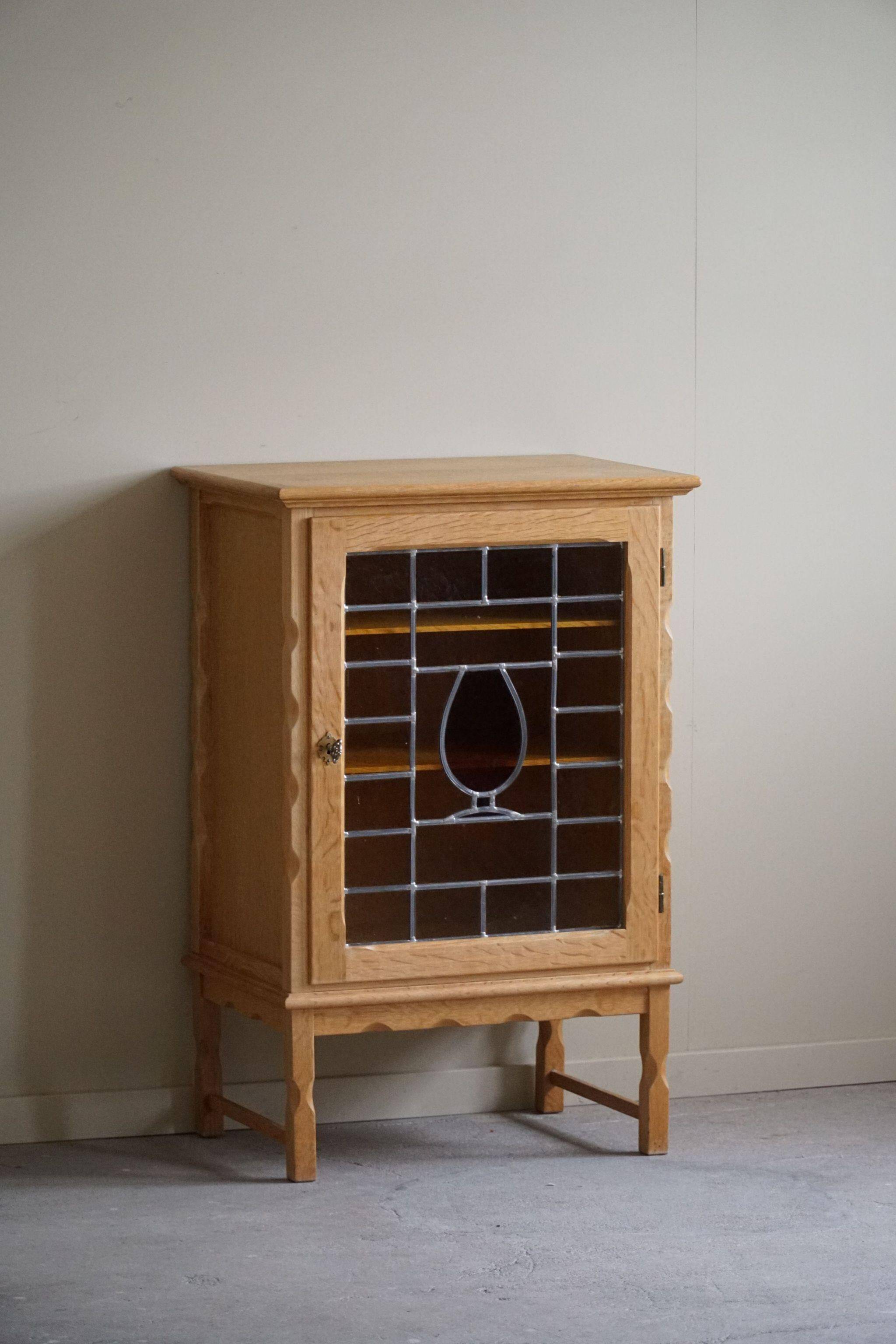 Scandinavian wardrobe in natural oak with a glass front.