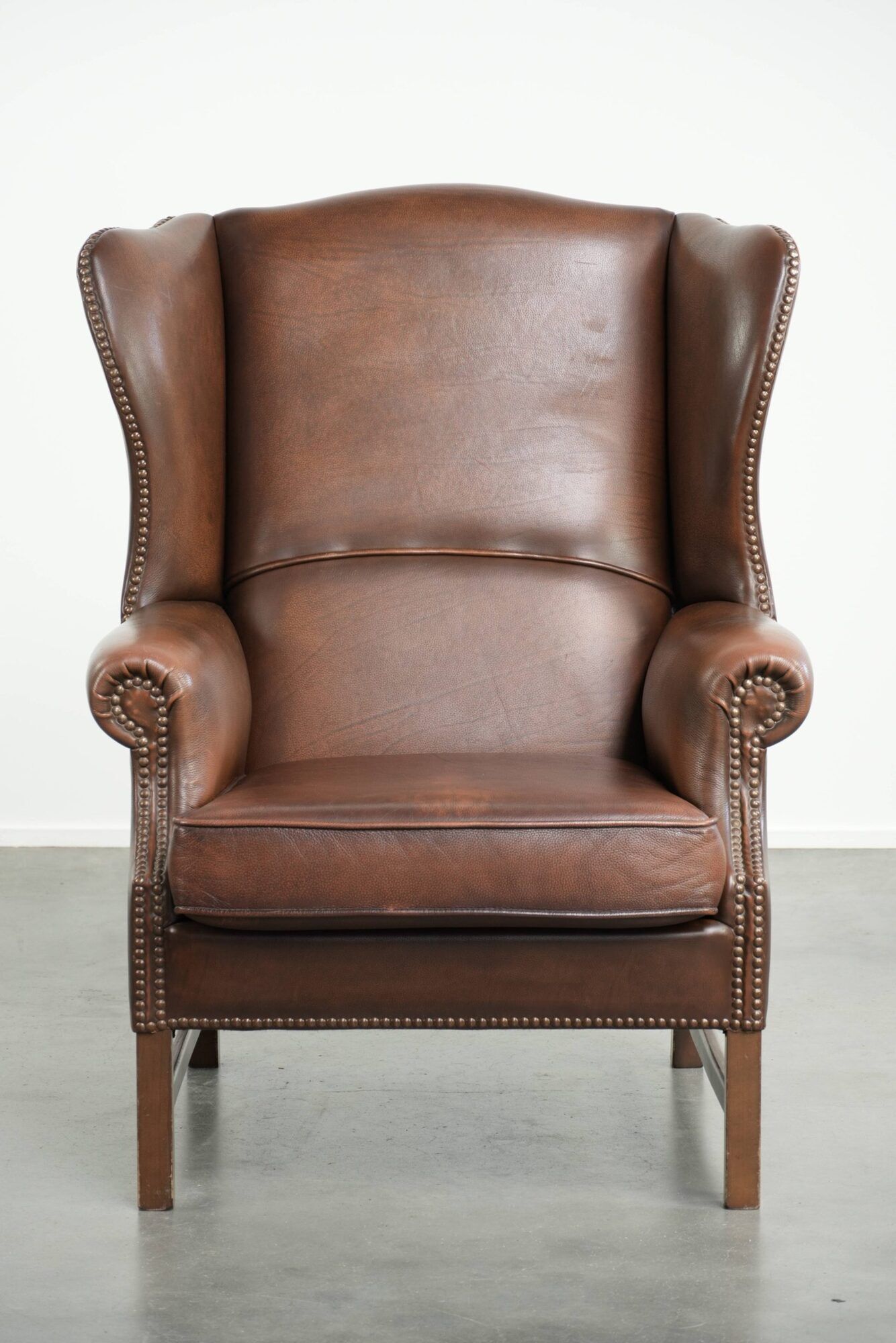 Cowhide wingback armchair in English style finished with decorative nails