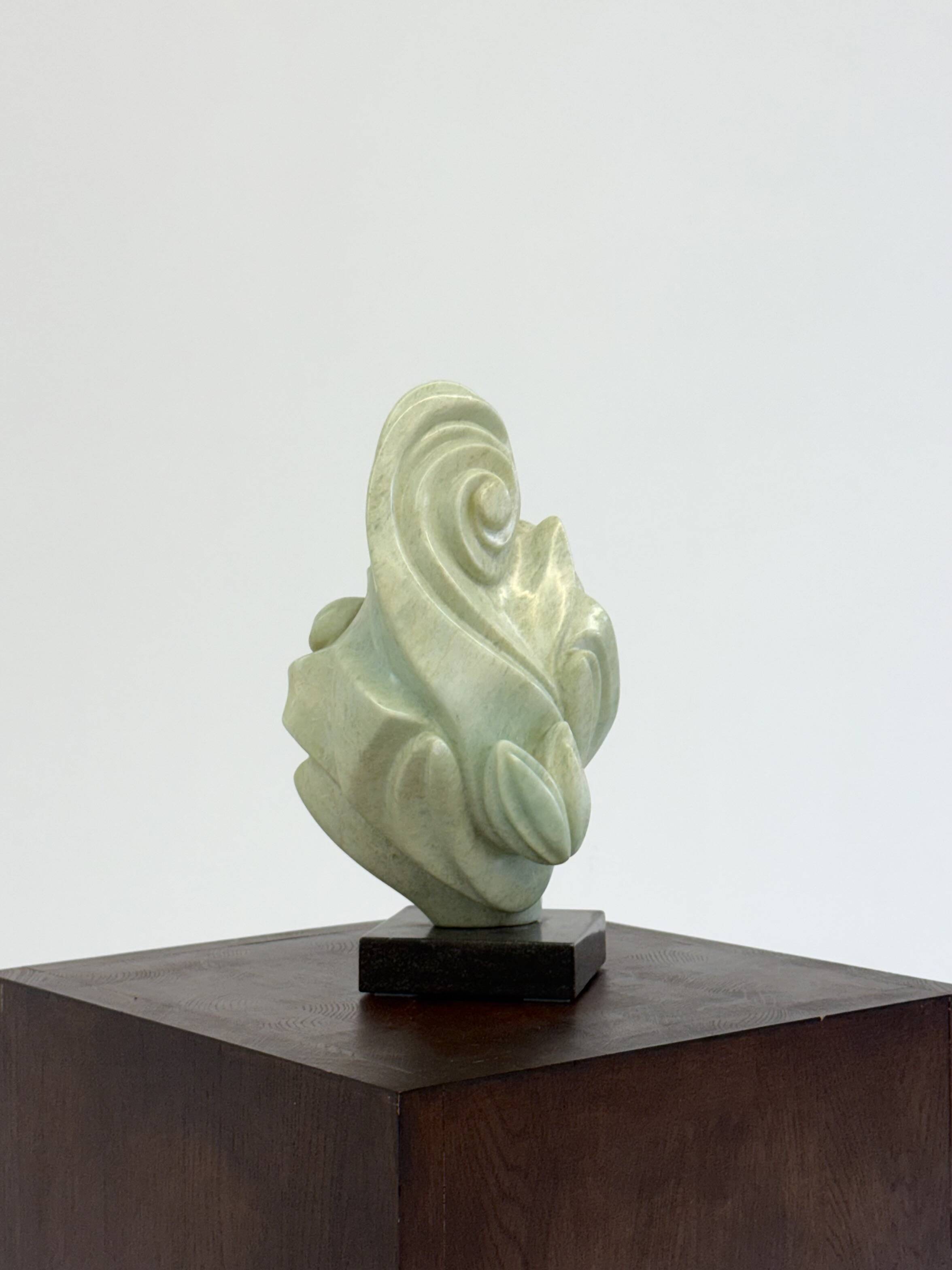 Green natural stone sculpture on marble base