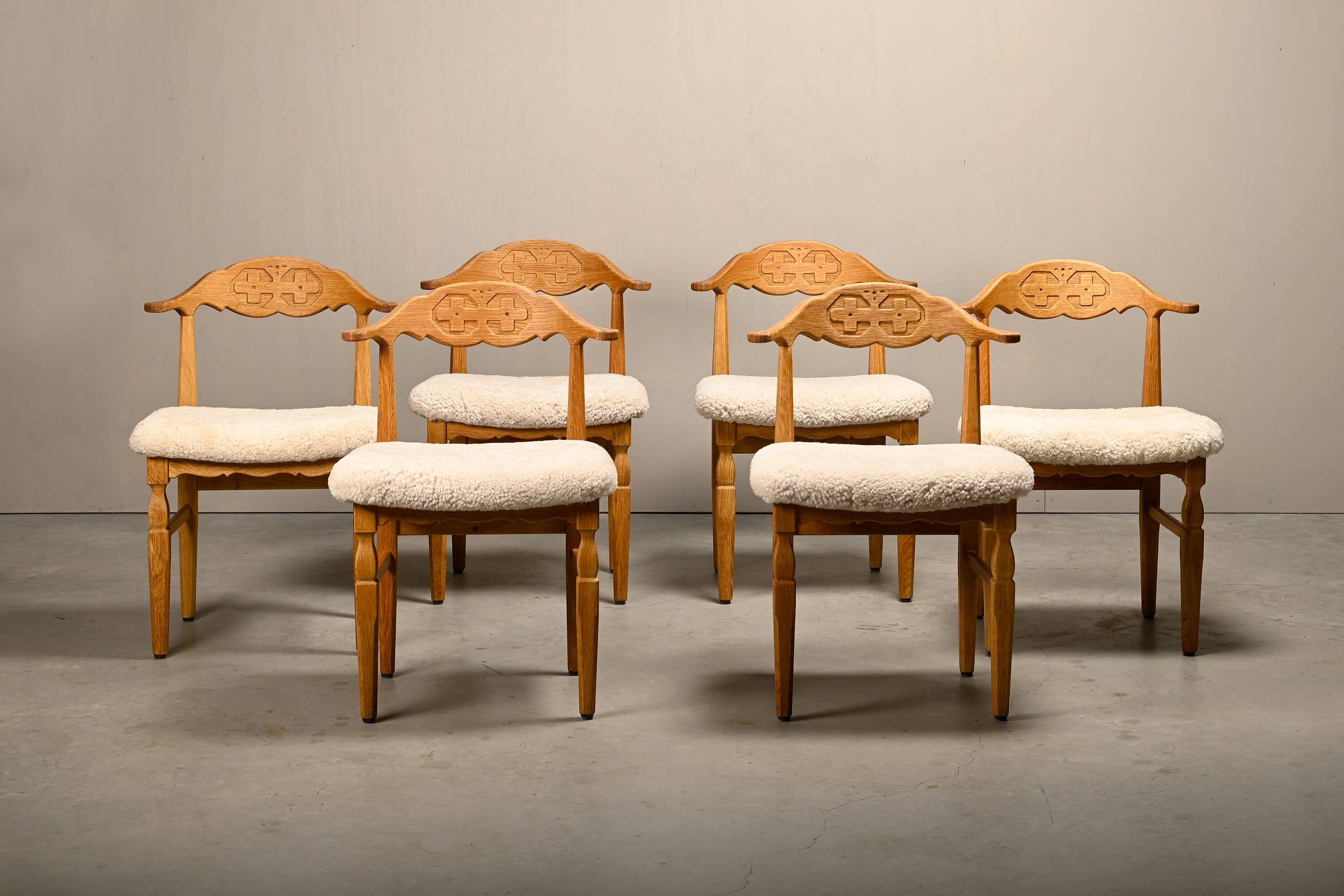 Henning Kjærnulf dining chairs set in Oak and Sheepskin, Denmark, 1960s