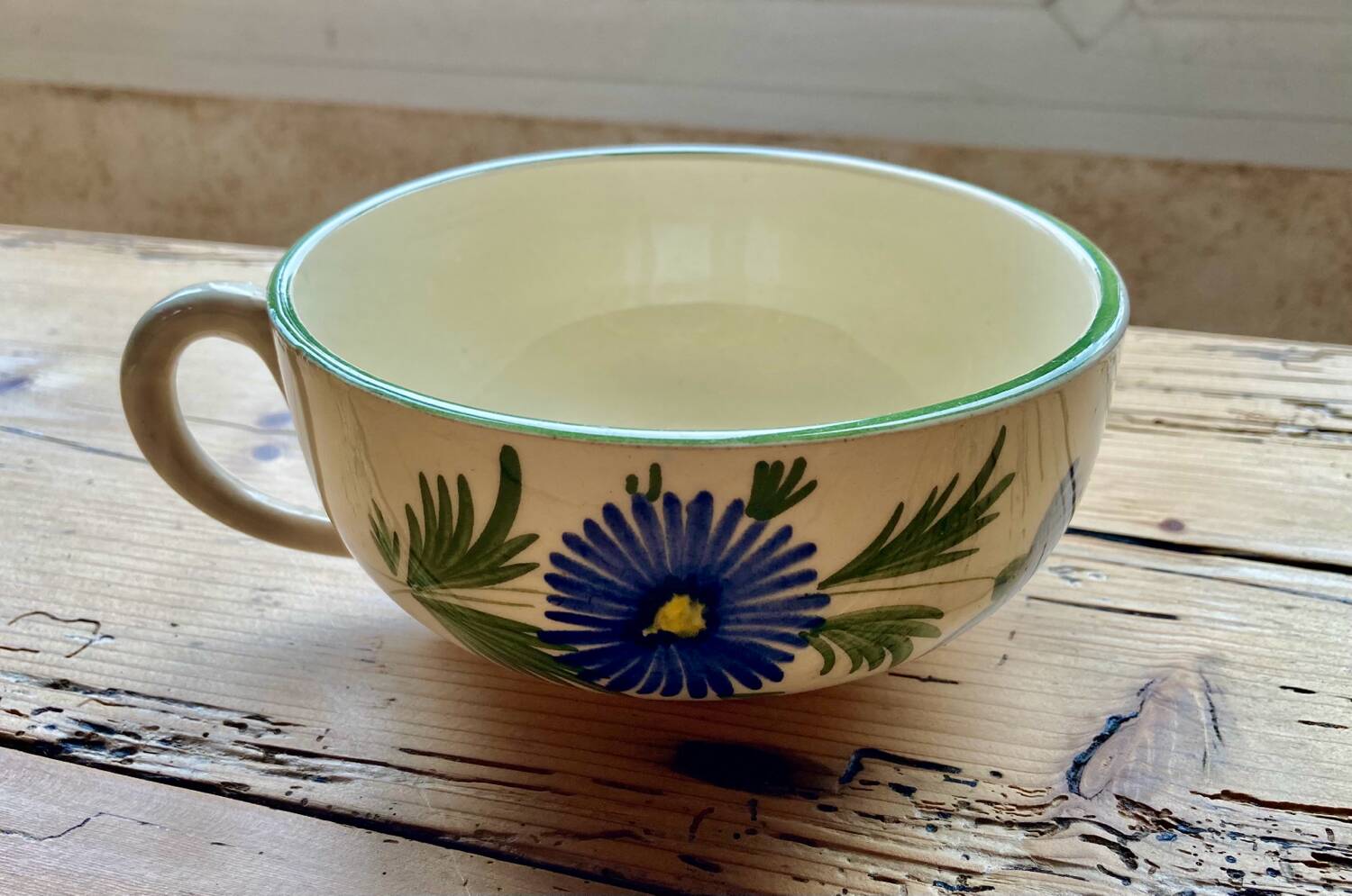Large cup and saucer in the quimper earthenware style.