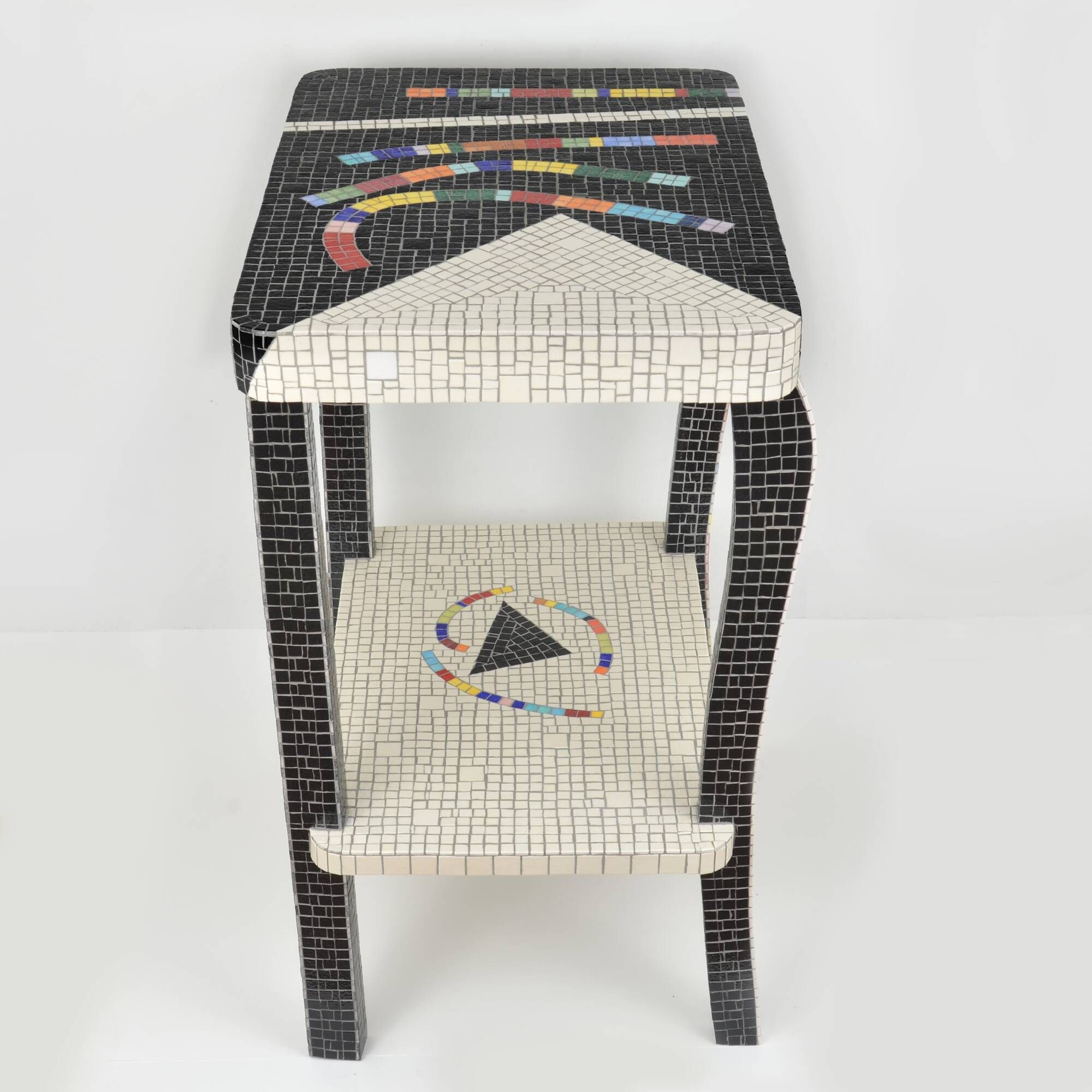 Table topped with a ceramic mosaic featuring an abstract design.